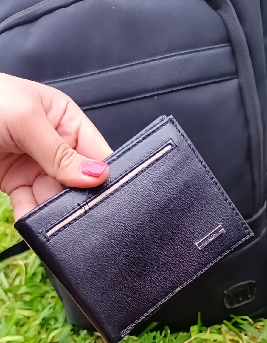 Billetera Aron negra junto a una mochila